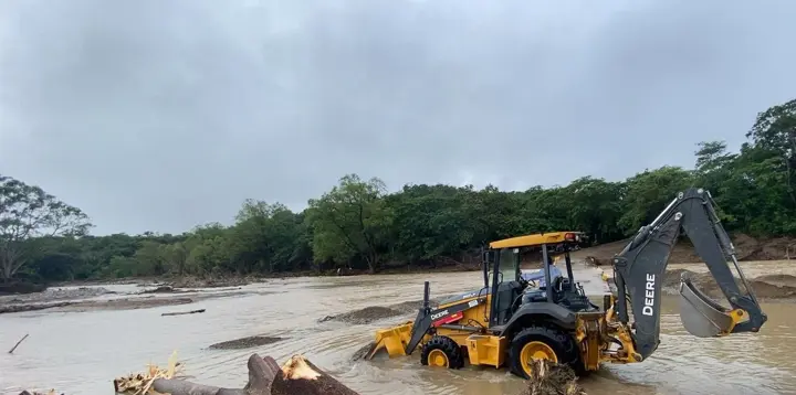 Retroexcavadora removiendo troncos del cauce